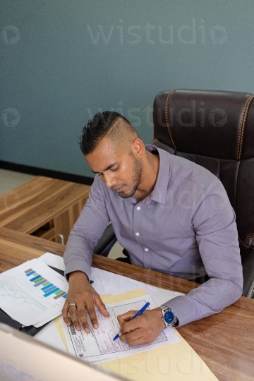 Male Employee in office doing reports