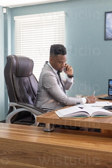 Male in office on the phone